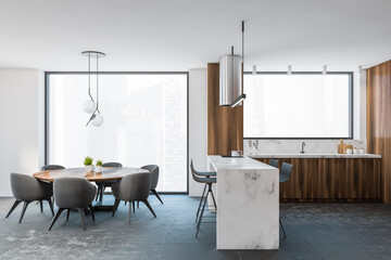 Modern gray and wooden kitchen with dining table and bar, side view