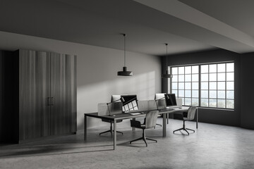 Modern gray open space office corner with wooden tables and wardrobe