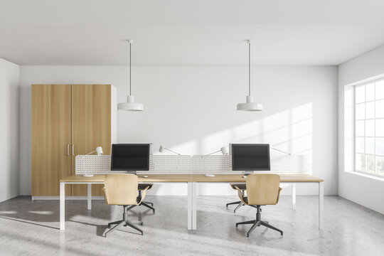 Modern white open space office interior with wooden tables and wardrobe