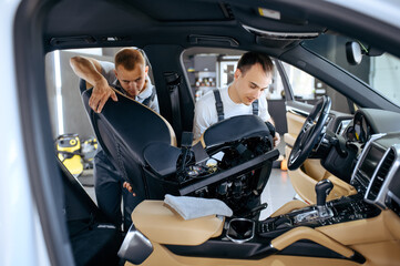 Naklejka premium Two workers removes car seats for detailing