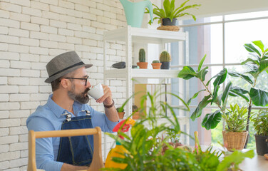 Elderly men Dignified dressing Happy with hobbies Sitting with a big desk Sitting and drinking coffee Along with a variety of trees In a room of the house