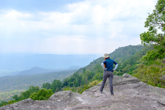 Woman standing on Pha Yeab Mek cliff at Phu Kradueng National Park in Amphoe Phu Kradueng, Loei Province.