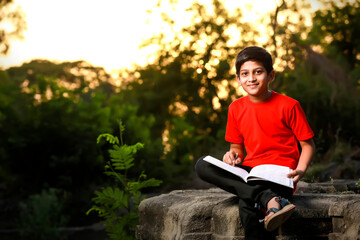 Indian / Asian school boy with note book and studying at home