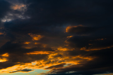 Naklejka na ściany i meble Beautiful sunset. Black and yellow clouds in the sky