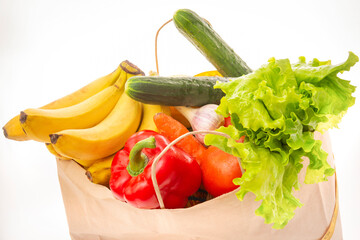 paper bag with vegetables and fruits on a white background, bananas, pepper, cucumber, lettuce, carrot, Apple