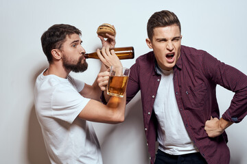 Two cheerful friends drinking beer drunk fun lifestyle communication light background