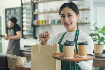 Fototapeta premium waitress Asian woman holds a coffee cup in a cafe.