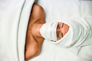 woman in a spa using a protective mask - new normal