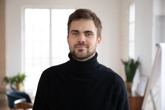 Profile picture of young Caucasian male employee posing in office. Headshot portrait of smiling millennial worker or company intern in workplace workspace. Employment, leadership, hr concept.