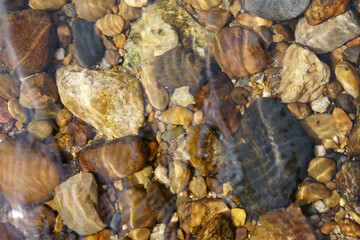 pebble or gravel and round stone beach in stream or river and pond with sea to clear transparent by clean water on top view or foot spa and nature massage and for texture background