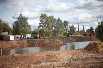 Fototapeta na wymiar Construction work on the pond. Landscape creation. Correction of the shores of the lake.