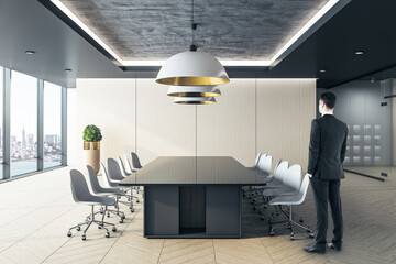 Businessman standing in boardroom with panoramic city view