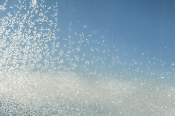 Naklejka na ściany i meble Ice crystals on the plane window. Frozen porthole glass and snow