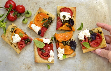 Puff pastry tomato tart with cottage cheese, pesto and basil, top view