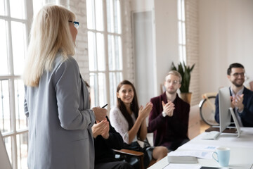 Close up view of excited diverse employee clap hands thanking female speaker or coach for...