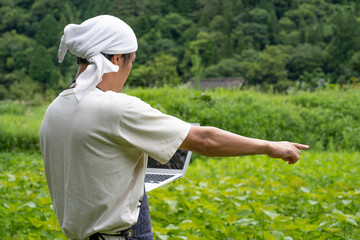 パソコンで農業をする男性
