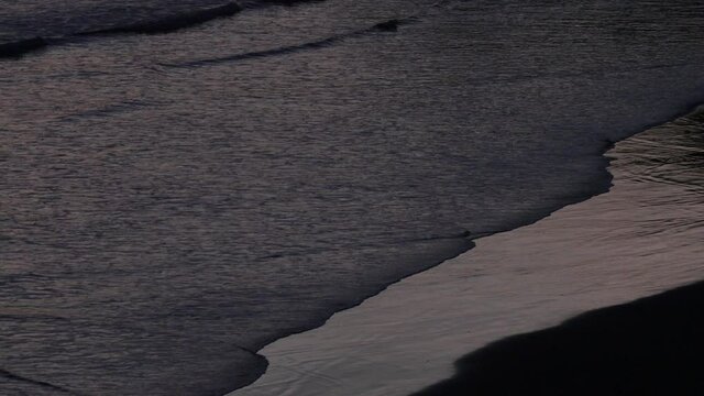 Medium, gentle waves crash on the beach at sunset, Costa Rica