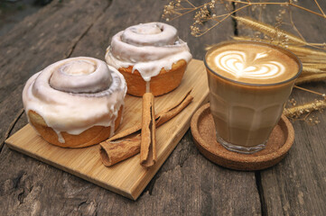 Cinnamon rolls and coffee latte on a wooden table