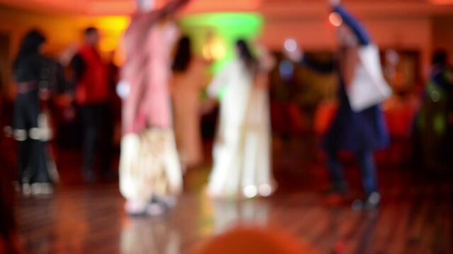 Medium, blurred silhouettes of people dancing at an Indian Wedding Celebration, USA