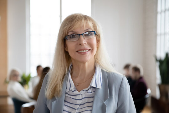 Headshot portrait of smiling middle-aged confident Caucasian businesswoman in glasses show confidence leadership. Profile picture of happy successful female employee worker in spectacles in office.
