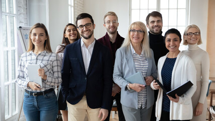 Portrait of smiling diverse team posing together in office show unity and support at workplace. Confident happy businesspeople or colleagues motivated for future shared success. Teamwork concept.