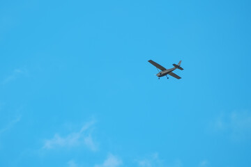 Small light aircraft flying in the blue sky