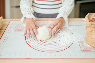 Woman hands kneading fresh dough for making bread