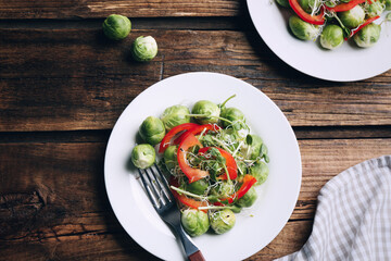 Tasty salad with Brussels sprouts served on wooden table, flat lay. Food photography