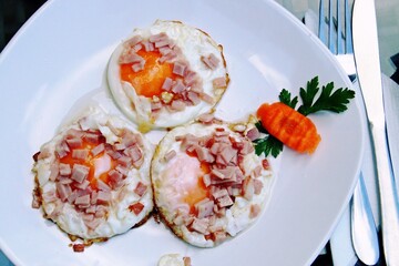 Huevos fritos con bacon para desayunar. Huevos fritos con aceite de oliva servidos en un restaurante de Rupea, Rumanía.