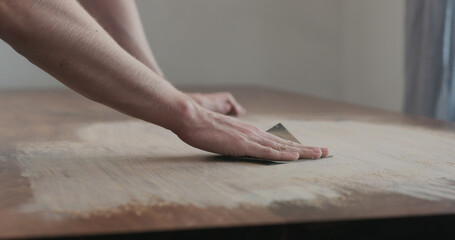 Fototapeta na wymiar man hand sanding black walnut wood table