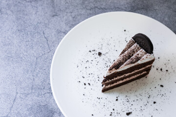 Cookie and Cream Cake is delicious on white plate and gray background.