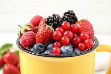 Mix of ripe berries in mug, closeup