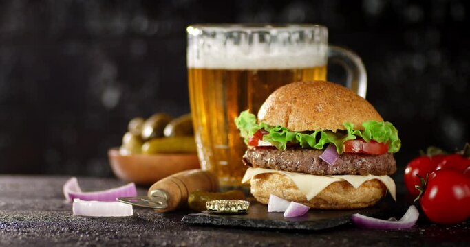 A burger with a beer is slowly rotating on the table. 