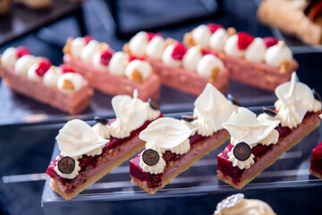 Sweet dessert table for catering and wedding with chocolate brownies and muscakes on dark background