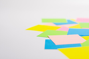 Rainbow colored paper sticky notes. Isolated on cork background.