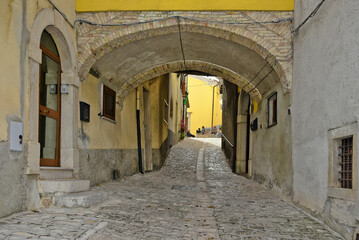Fototapeta na wymiar A narrow street among the old houses of Mirabello Sannitico, a medieval village in the province of Campobasso, Italy