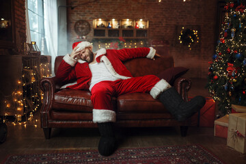 Bad Santa claus with hangover sitting on couch