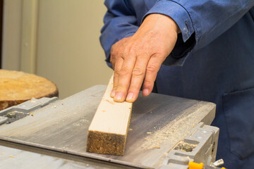 an elderly carpenter handles the bar on the machine. men's work with tools. High quality photo