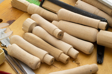wooden blanks to replace the handles of tools .a lot of details in on the table in the carpentry workshop.