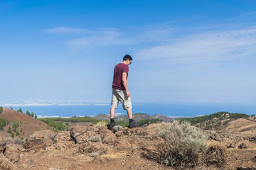 Naklejka premium Young hiker walking between rocks