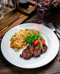 grilled meat and couscous on wood table