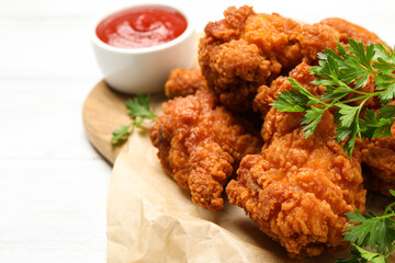 Tasty deep fried chicken pieces served on table, closeup