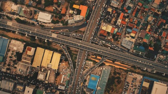 Top down of traffic roads at Manila town cityscape aerial view. Amazing urban scenery with slow cars and buses motion on roadway. Downtown skyscrapers, buildings roofs of Philippines capital city
