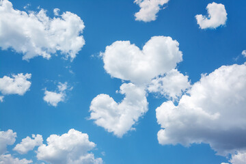 Fototapeta na wymiar Bright picture of clouds in shape of two hearts between other clouds in blue sky. Concept of love, feelings, relationship between people