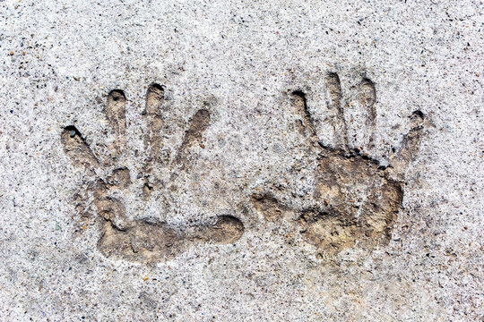 Imprints of two children's hands in concrete.