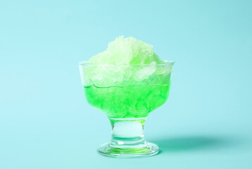Shaving ice in glass dessert bowl on light blue background