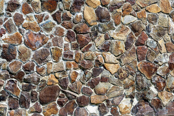 The surface is covered with stones of different shapes as a background, texture, pattern.