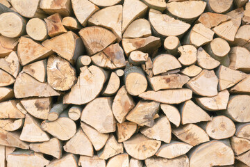 Many chopped firewood is neatly stacked as a background, texture, pattern.