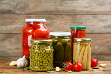 Jars of pickled vegetables on wooden table