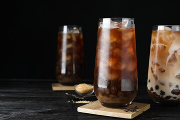Tasty brown milk bubble tea on black wooden table. Space for text